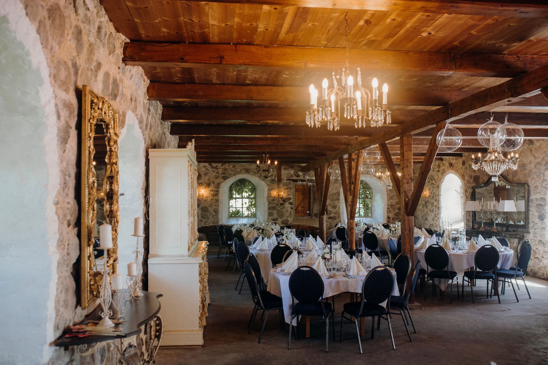 Restorano salė su akmens sienomis, medinėmis sijomis ir sietynais